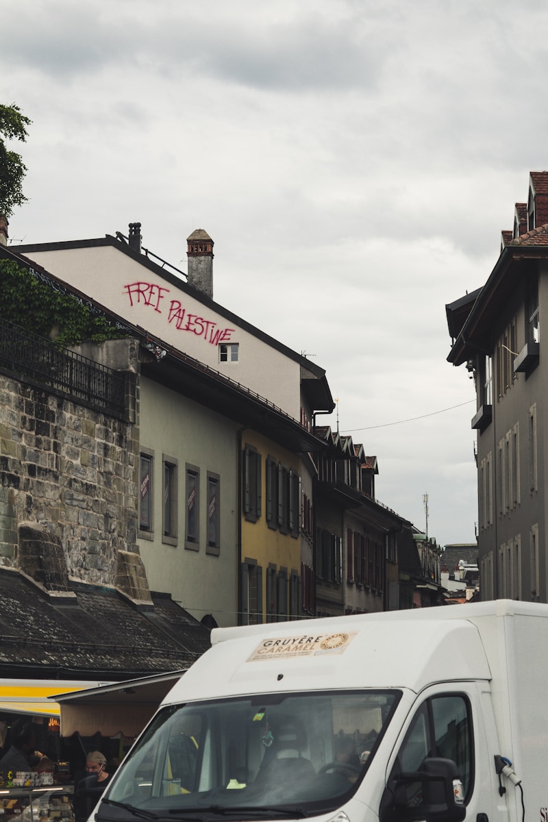 white van parked beside gray concrete building during daytime